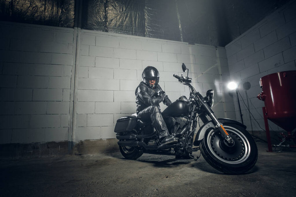 Motociclista com sua moto na garagem
 - Foto, Imagem