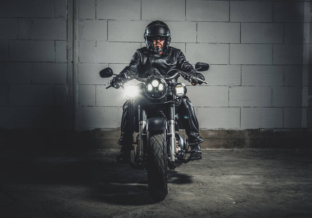 Biker con su moto en el garaje
 - Foto, Imagen