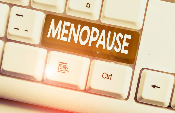Fogalmi kézzel írásban mutatja menopauza. Üzleti fotószöveg a peranalysisent megszűnése, vagy a menstruáció vége, fehér PC billentyűzet a fehér háttér felett Jegyzetpapír. - Fotó, kép