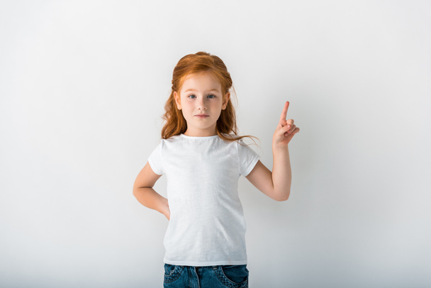 mignon rousse enfant regardant caméra et pointant du doigt sur blanc
  - Photo, image