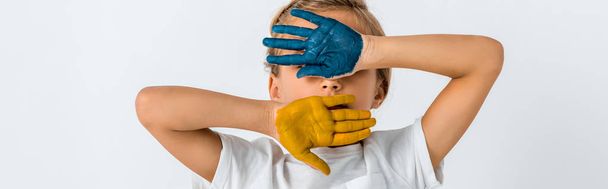 panoramic shot of kid with paint on hands covering face isolated on white  - Photo, image
