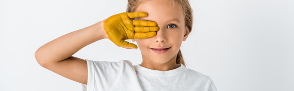 plan panoramique de l'enfant avec de la peinture à la main couvrant le visage isolé sur blanc
  - Photo, image