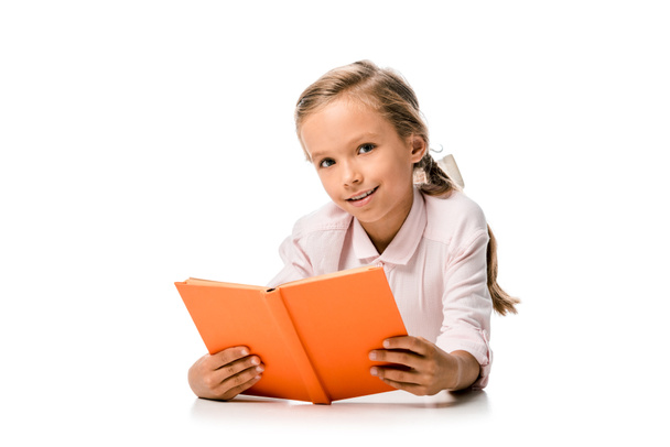happy schoolkid holding orange book and smiling on white  - Фото, изображение
