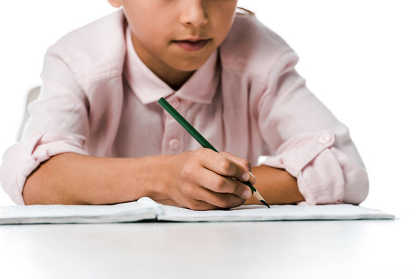 vue recadrée d'un écolier tenant un crayon près d'un cahier sur blanc
  - Photo, image