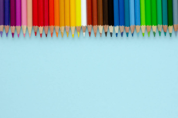 Colored pencils composition on blue background. Flat lay. - Fotó, kép