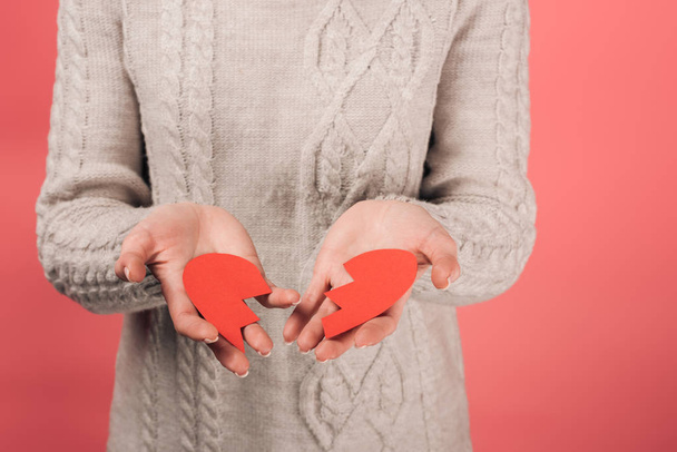 cropped view of woman holding paper artwork with broken heart on pink  - Фото, зображення
