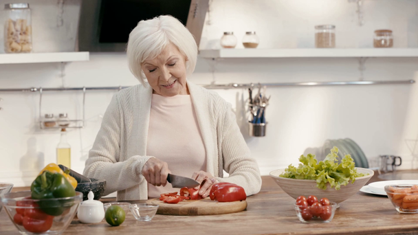 smiling woman cutting bell pepper  - Záběry, video