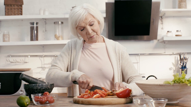 Lächelnde Frau schneidet Paprika - Filmmaterial, Video