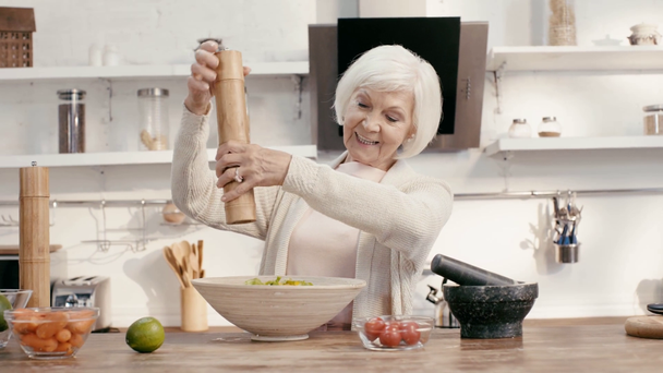 smiling woman seasoning salad with salt  - Felvétel, videó
