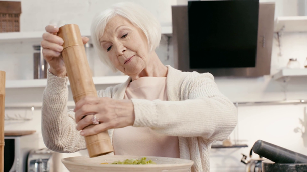 uśmiechnięta kobieta przyprawy sałatka z pieprzem i młynów soli  - Materiał filmowy, wideo