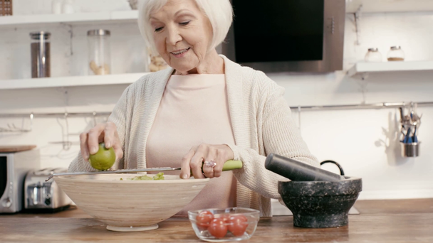 smiling woman grating lime to salad  - Filmmaterial, Video