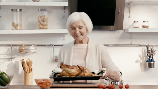 Lächelnde Frau legt schmackhaften Truthahn auf den Tisch  - Filmmaterial, Video