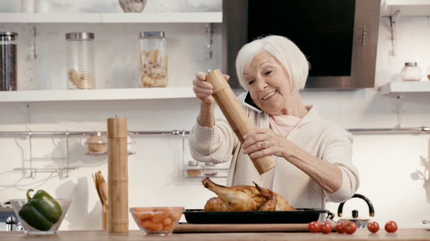 woman seasoning turkey and talking on smartphone  - Séquence, vidéo