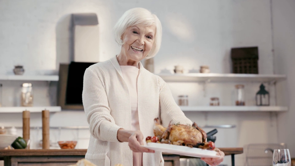Lächelnde Frau legt schmackhaften Truthahn auf den Tisch  - Filmmaterial, Video