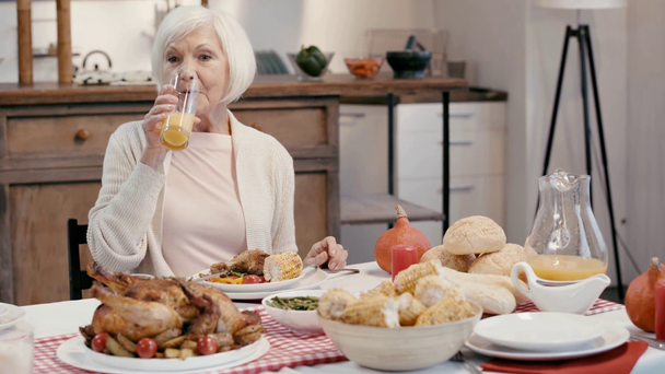 Lächelnde Frau trinkt Saft und isst Essen  - Filmmaterial, Video