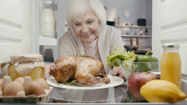 donna sorridente che prende piatto con tacchino dal frigorifero
 - Filmati, video