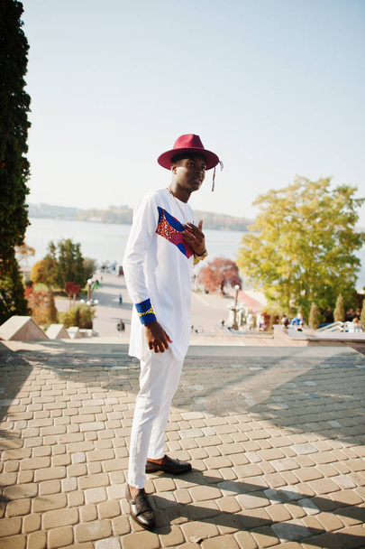 Stylish trendy afro france man in red hat and white outfit posed - 写真・画像