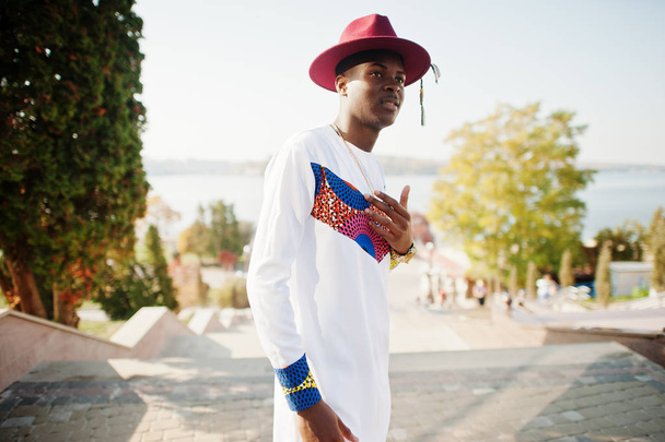 Stylish trendy afro france man in red hat and white outfit posed - Fotó, kép