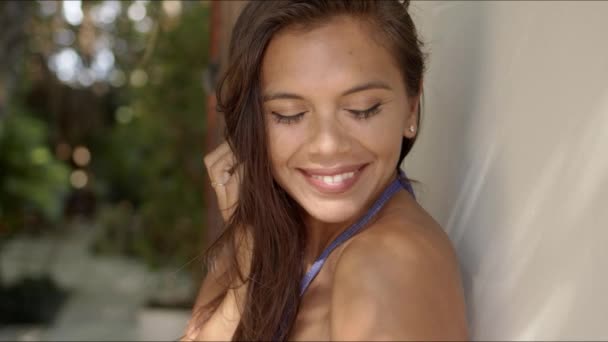 Mujer atractiva con hombros desnudos mirando a la cámara y sonriendo
 - Metraje, vídeo