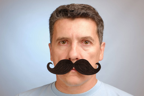 Портрет человека с фальшивыми усами для участия в мероприятии в ноябре, чтобы помочь мужчинам осведомленности о проблемах со здоровьем
. - Фото, изображение