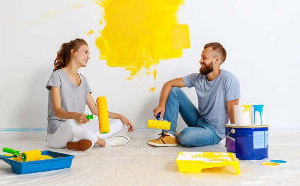 joven feliz pareja está reparando y pintando la pared en hom
 - Foto, imagen