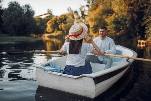 Aşk çifti yaz günü gölde kayıkla geziyor. Romantik veriler, tekne gezisi, nehirde yürüyen adam ve kadın. - Fotoğraf, Görsel