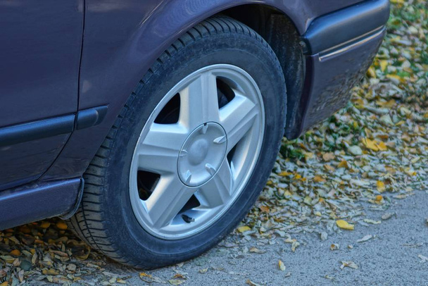 carro marrom com uma roda no asfalto
 - Foto, Imagem