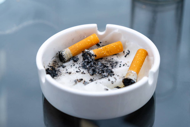 White dirty ashtray with cigarette stubs. Cigarette. - Photo, Image
