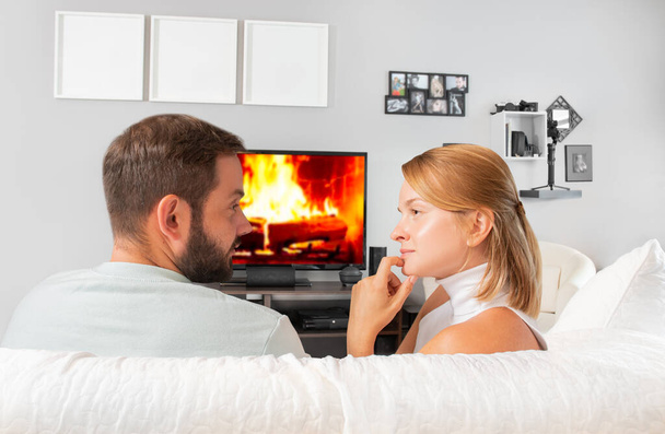 Young couple watching television at home - 写真・画像