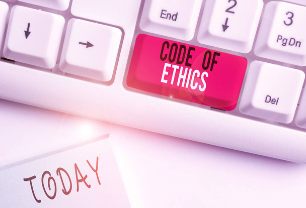 Conceptual hand writing showing Code Of Ethics. Business photo text basic guide for professional conduct and imposes duties White pc keyboard with note paper above the white background. - Photo, Image