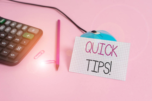 Handwriting text Quick Tips. Concept meaning small but particularly useful piece of practical advice Wire mouse clips marker calculator squared paper sheet colored background. - 写真・画像