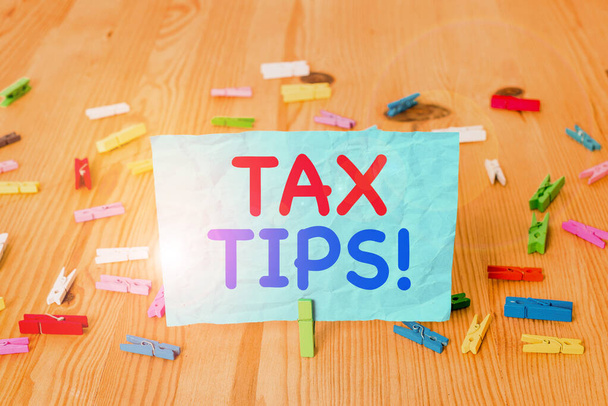 Word writing text Tax Tips. Business concept for compulsory contribution to state revenue levied by government Colored clothespin papers empty reminder wooden floor background office. - Photo, Image