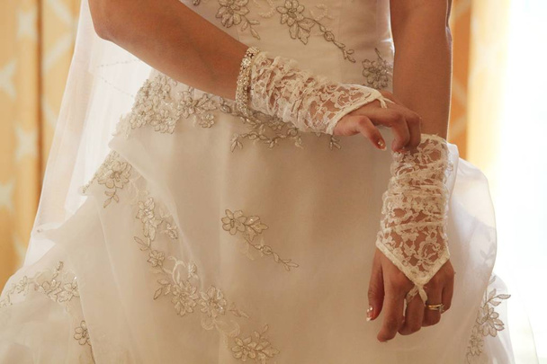 Mariée arrangeant ses gants de dentelle blanche avant le mariage
 - Photo, image