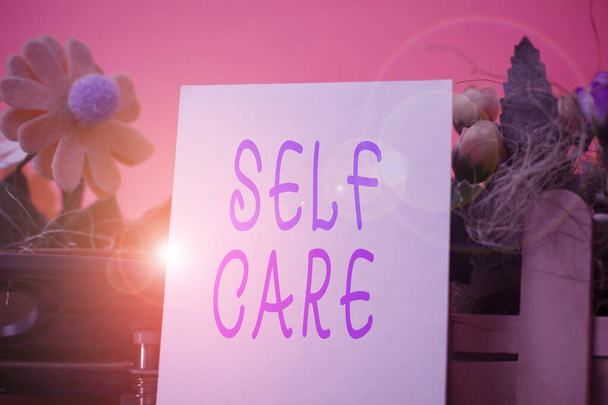 Handwriting text Self Care. Concept meaning the practice of taking action to improve one s is own health Flowers and writing equipments plus plain sheet above textured backdrop. - Photo, Image
