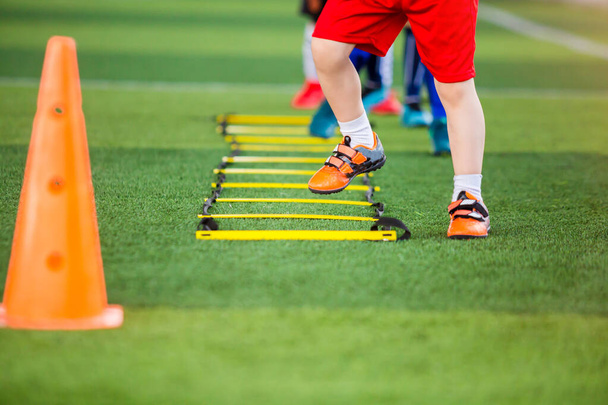 Dětský fotbalista joggingu a skok mezi značkou pro fotbal - Fotografie, Obrázek