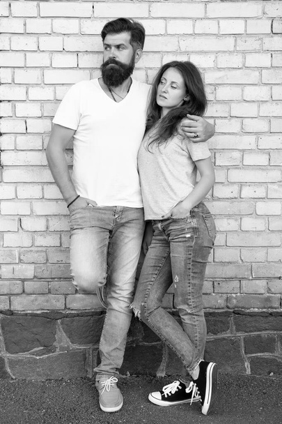 Couple in love. Family couple hugging on brick wall background. Bearded man and sexy woman cuddling. Sensual couple together. Family day. Careful hug of loving people. Just hang out together - Photo, Image