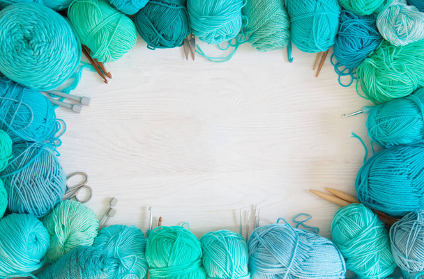 Yarn of green, turquoise, aquamarine and blue colors. White wood - Foto, afbeelding