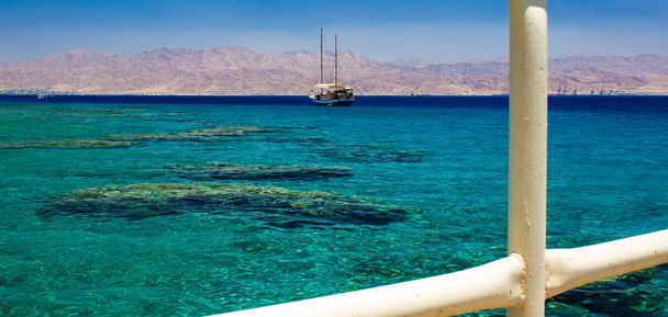 verano temporada de vacaciones paraíso Oriente Medio lugar vista panorámica Mar Rojo playa de coral con crucero y Jordania desierto montañas fondo
 - Foto, Imagen