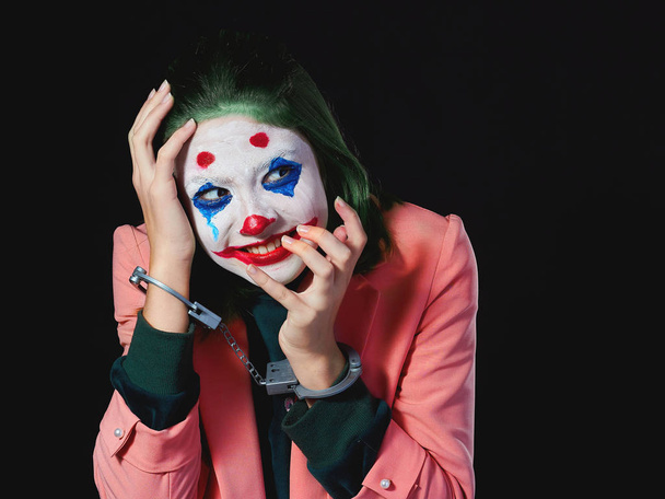 Maquillaje para mujer de Halloween en traje de Joker sobre fondo negro rodaje en Studio
. - Foto, Imagen