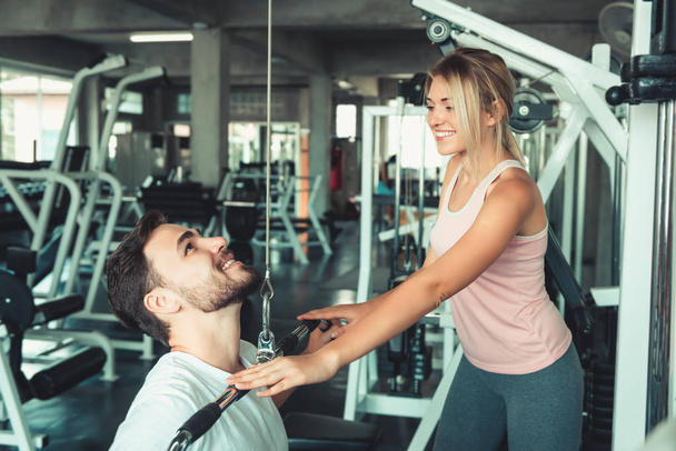 Portrait of Handsome Man is Exercised Training With Bodybuilder Machine in Fitness Club., Attractive of Sporty Man Doing Working Out With His Trainer in Gym, Healthy and Sport Lifestyle Concept. - Photo, Image