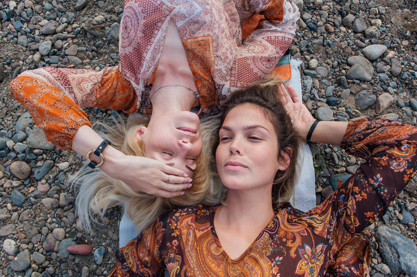 Two beautiful young women brunette and blond laying head to head. - Valokuva, kuva