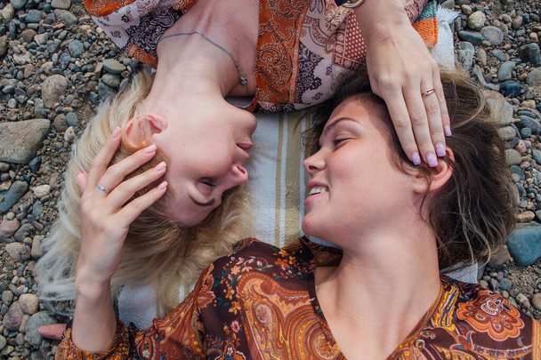 İki güzel genç kadın esmer ve sarışın kafa kafaya yatıyorlar.. - Fotoğraf, Görsel