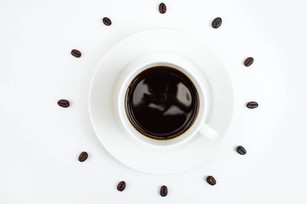 Koffie met koffiebonen omgeven op een witte achtergrond. - Foto, afbeelding