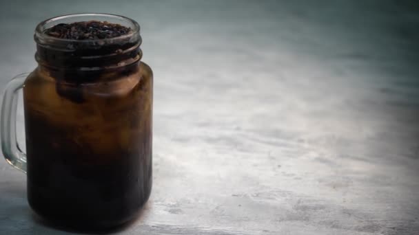 close-up πλάνα του παγωμένου τσαγιού σε βάζο mason και γκρι φόντο - Πλάνα, βίντεο