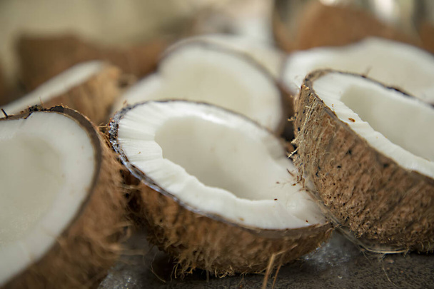 Suszone kokosy są krojone na pół słodkie, organiczne, wiele kokosów, kokosy cięte, stos orzechów kokosowych, biały, pęknięty kokos, dwie części, rolnictwo, świeże brązowe kokosy, kawałki, składniki odżywcze, tropikalne, owoce, płody - Zdjęcie, obraz