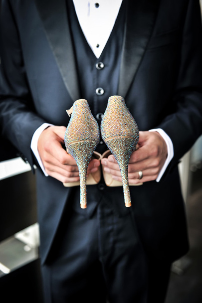 Groom tenant des chaussures de mariée
 - Photo, image