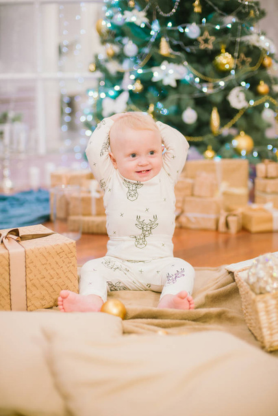 Little toddler boy at home at the Christmas tree with gifts and toys. Christmas mood - Фото, зображення