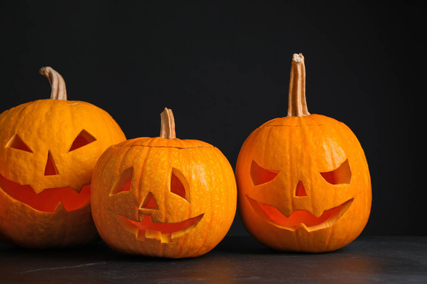 Kürbisse mit gruseligen Gesichtern auf schwarzem Hintergrund. halloween traditi - Foto, Bild