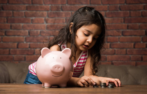 Indian small girl with piggy bank - saving concept - Photo, Image