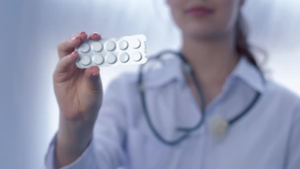 таблетки в руці медичної дівчини на білому тлі в не орієнтованому
 - Кадри, відео